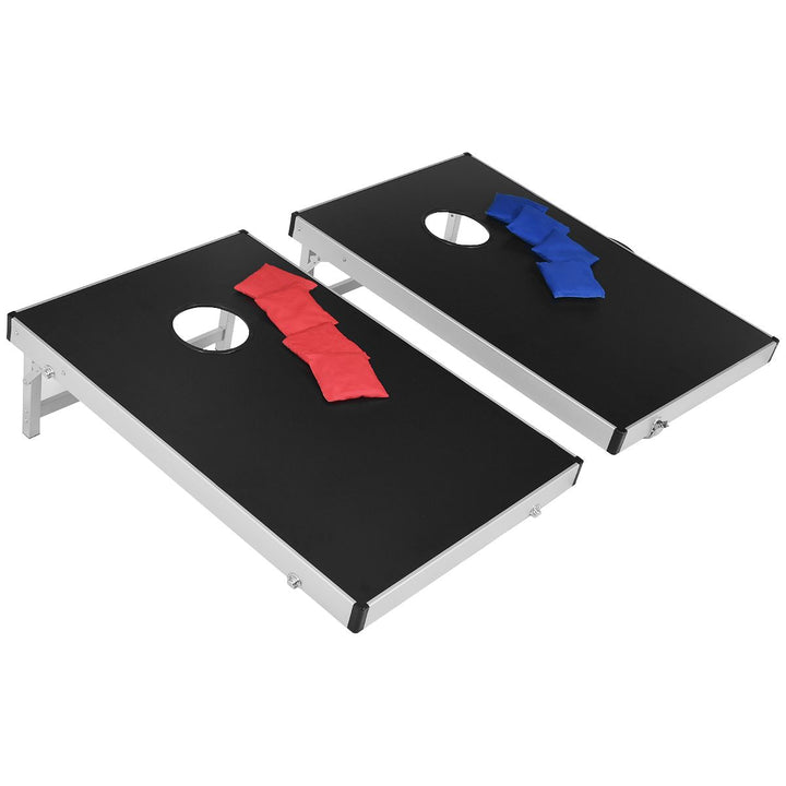 Two black cornhole boards with four red and four blue beanbags