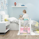 Child holding both side handles while standing on the lower step of the Pink stool