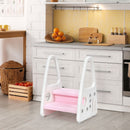 Pink and white two-step stool beside a kitchen cabinet