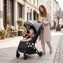 Grey folding stroller, outdoor lifestyle view