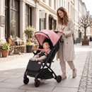 Pink folding stroller, outdoor lifestyle view