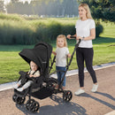 Black sit and stand double stroller, outdoor use with front seat and rear standing platform