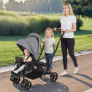 Grey sit and stand double stroller, outdoor use with front seat and rear standing platform