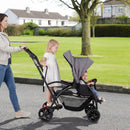 Grey sit and stand double stroller, side view of seated and standing travel positions
