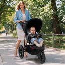 Black three-wheel stroller, outdoor front view