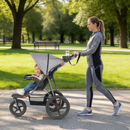 Grey three-wheel stroller, outdoor side view