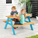 Children seated at the outdoor picnic table