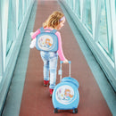 Child wearing the blue mermaid backpack and pulling the matching suitcase, with the photographed pillow and tag.