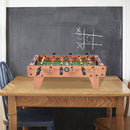 Tabletop foosball game on a table in an unoccupied room; table and chair are not included
