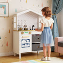 White house-shaped wooden play kitchen, pretend play scene