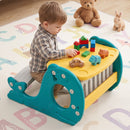 Yellow activity table and integrated bench in use; toys are styling props