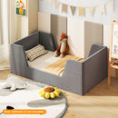Grey velvet upholstered toddler bed frame with shaped side panels in a styled room; mattress not included