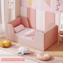 Pink velvet upholstered toddler bed frame with shaped side panels in a styled room; mattress not included