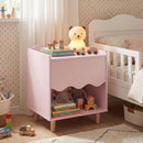 Pink scalloped bedside table beside a bed