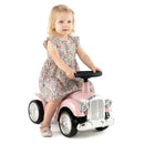 Child seated on retro ride-on car – Pink