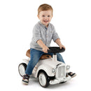 Child seated on retro ride-on car – White