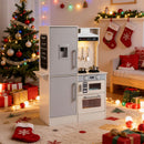 White dual-sided wooden play kitchen in a styled room; decorations are not included
