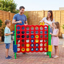 Green uprights and coloured four-in-a-row board shown during an outdoor family game