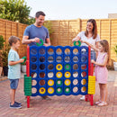 Red uprights and coloured four-in-a-row board shown during an outdoor family game