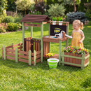 Child using the brown and green mud farm wash station in a garden; plants and play props excluded