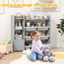 Grey kids storage organiser with eight bins and a side cabinet: child beside organiser