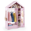 Pink house-shaped kids wardrobe with mirror door and hanging rail; clothing and toys are styling props
