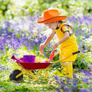 Red wheelbarrow in a garden scene with play tools and watering cans that are not included