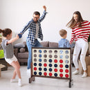 Family gathered around the Natural wooden four-in-a-row game indoors