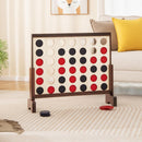 Natural wooden four-in-a-row game arranged beside a sofa with red and blue chips