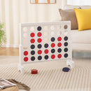 White wooden four-in-a-row game arranged beside a sofa with red and blue chips